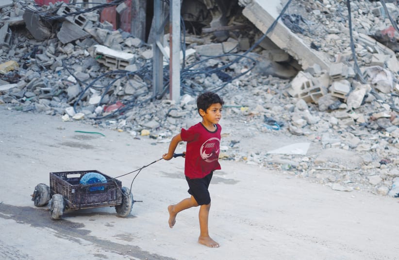  A PALESTINIAN boy pulls a water container amid shortages, in Khan Yunis in the southern Gaza Strip, this week. Despite the plight of millions of Palestinians in Gaza, Hamas is in no hurry because it believes time is on its side, says the writer. (photo credit: MOHAMMED SALEM/REUTERS)