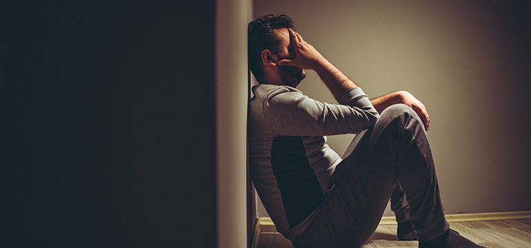 Depressed man sitting on the floor