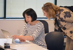 female instructor helping female student at her desk
