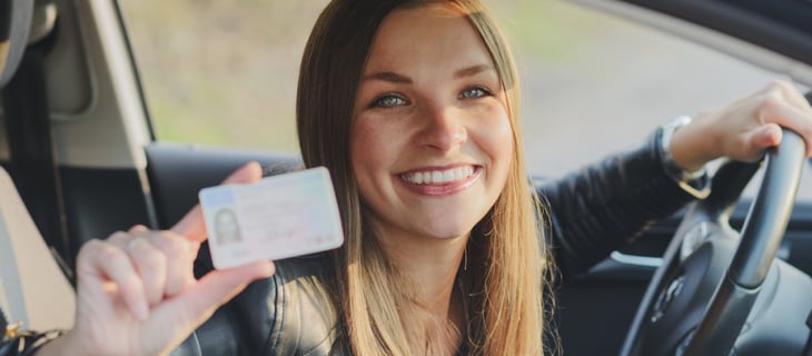 Teenage driver holding up driver's license