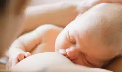 אימא מניקה תינוק ומחזיקה את ראשו