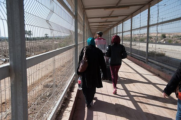 Palestinians walk through the kilometer-long caged terminal through the "no-go zone" between Israel's Erez Crossing and Beit Hanoun, Gaza Strip, December 18, 2013. (Ryan Rodrick Beiler/Activestills)
