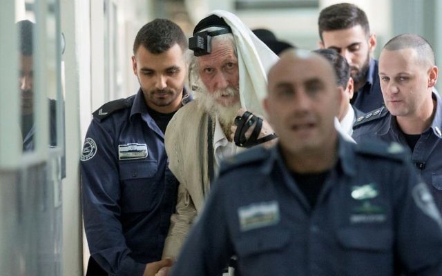 Rabbi Eliezer Berland covers himself with his talit (prayer shawl) at the Jerusalem Magistrate's Court during his trial for sexual assault charges on November 17, 2016. (Yonatan Sindel/Flash90