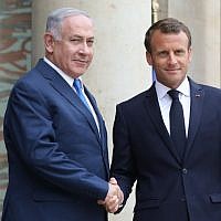French President Emmanuel Macron shakes hands with Prime Minister Benjamin Netanyahu (L) at the Elysee Palace in Paris on June 5, 2018. (AFP/Ludovic Marin)
