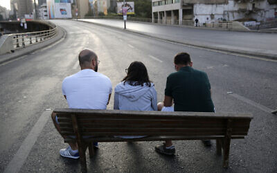 Anti-government protesters sit in the middle of a main highway during ongoing protests against the Lebanese government, in Beirut, Lebanon, October 28, 2019. (AP Photo/Hussein Malla)