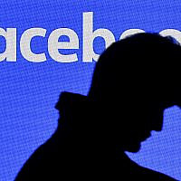 Illustrative: A man passes a Facebook screen at the Gamescom gathering in Cologne, Germany, August 20, 2019. (AP Photo/Martin Meissner)