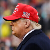 US President Donald Trump wears a red hat as he stands on the field before the Army-Navy college football game in Philadelphia, on December 14, 2019. (AP/Jacquelyn Martin)