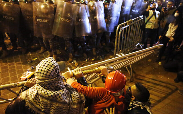 Anti-government protesters try to remove fences that divided between them and the riot police during a protest near the parliament square in downtown Beirut, Lebanon, Sunday, Dec. 15, 2019. (AP Photo/Hussein Malla) Anti-government protesters try to remove fences that divided between them and the riot police during a protest near the parliament square in downtown Beirut, Lebanon, Sunday, Dec. 15, 2019. (AP Photo/Hussein Malla)