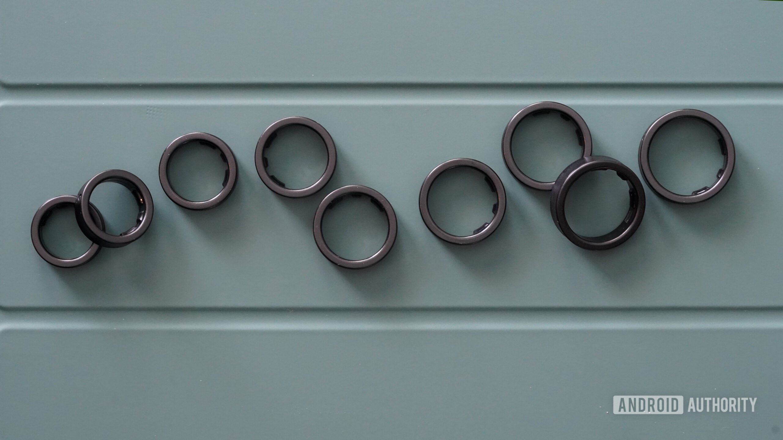 Samsung Galaxy Ring Sizing Rings Samsung Galaxy Ring Sizing Rings sized 5 through 13 rest on a green surface.