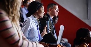 Woman of color holding a microphone 