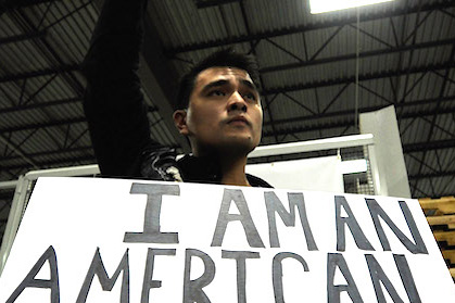 Vargas looking on holding sign that reads: I am an American
